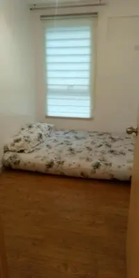 an unmade bed in a bedroom with a window at Kali's Pad in Manila