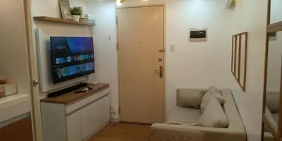 a living room with a couch and a flat screen tv at Kali's Pad in Manila