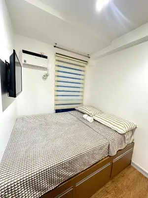 a small bedroom with a bed and a television at Kali's Pad in Manila