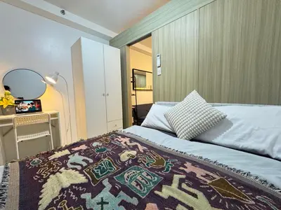 a bedroom with a bed with a rug on it at MOA Staycation at Shore Residences Tower C in Manila