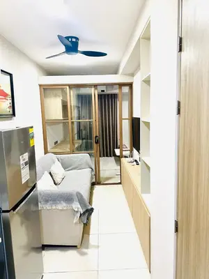 a living room with a couch and a ceiling fan at One-bedroom condo within the city at S Residences in Manila