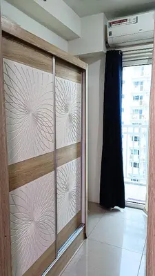 a sliding glass door in a room with a window at Pool view from one-bedroom condo at Shore Residence in Manila