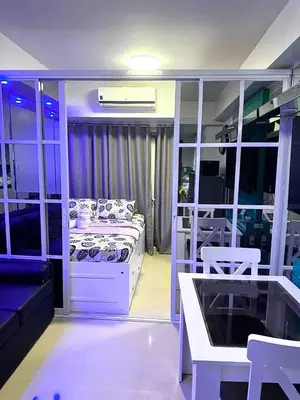 a room with a bed and a couch and a table at One-bedroom condo at Shell Residences in Manila