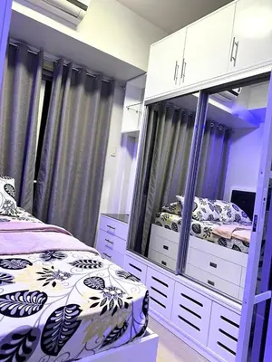 a bedroom with two beds and a large mirror at One-bedroom condo at Shell Residences in Manila