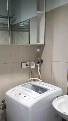 a bathroom with a sink and a toilet and a mirror at One-bedroom condo at Shell Residences in Manila