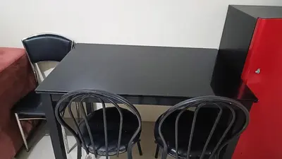 a black table and two chairs in a room at Spacious simple one-bedroom condo at Shell Residence in Manila