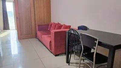 a living room with a couch and a table and chairs at Spacious simple one-bedroom condo at Shell Residence in Manila