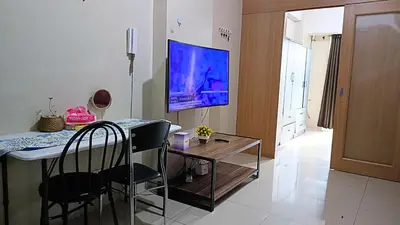 a living room with a table and a tv on the wall at Spacious simple one-bedroom condo at Shell Residence in Manila