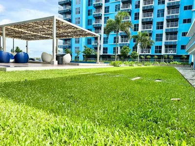 a large grassy area in front of a large building at Modern Seaview 1BR Near Okada Manila Bay Airport 17 in Manila