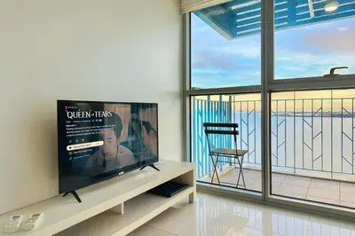 a living room with a flat screen tv and a chair at Modern Seaview 1BR Near Okada Manila Bay Airport 17 in Manila