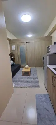 a living room with a table in the middle of a room at JNDhome in Manila