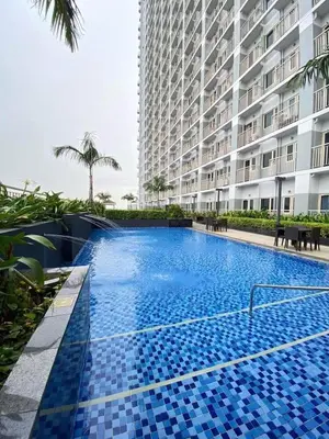 a large swimming pool in front of a building at Cozy 1 Bedroom unit in Manila in Manila