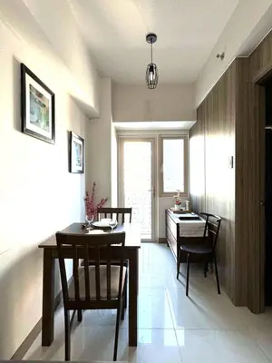 a living room with a table and chairs and a dining room at Cozy 1 Bedroom unit in Manila in Manila