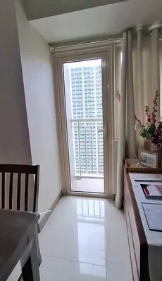 a living room with a large window and a kitchen at Cozy 1 Bedroom unit in Manila in Manila