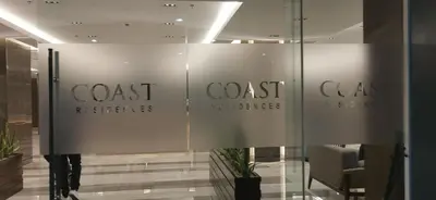 a glass wall in a lobby with a sign for coast fractures at Cozy 1 Bedroom unit in Manila in Manila