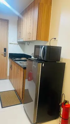 a kitchen with a microwave on top of a refrigerator at Luna Suite in Manila