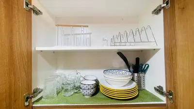 a cabinet with plates and bowls on a shelf at Luna Suite in Manila