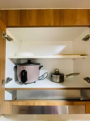 a pot and a pan on a shelf in a kitchen at Luna Suite in Manila
