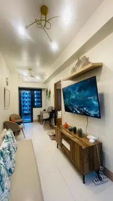 a living room with a large flat screen tv on a wall at Luna Suite in Manila