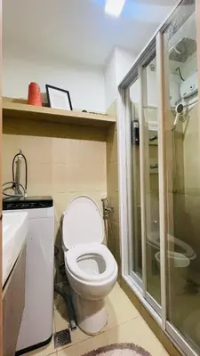a bathroom with a toilet and a sink and a shower at Luna Suite in Manila