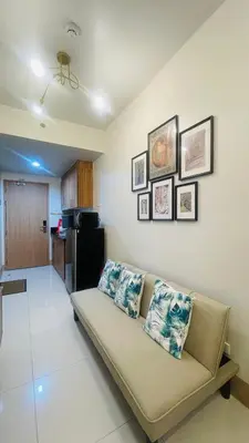 a living room with a couch and a kitchen at Luna Suite in Manila
