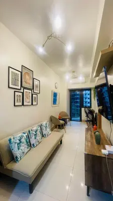 a living room with a couch and a tv at Luna Suite in Manila