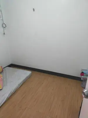 a room with a bed and a wooden floor at May homey vibe in Pasig