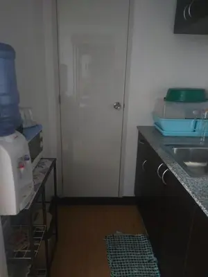 a kitchen with a white door and a sink at May homey vibe in Pasig