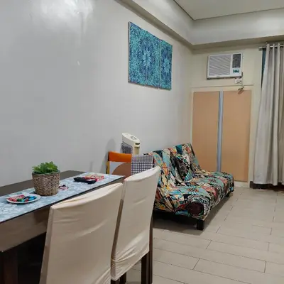 a living room with a table and a couch at LDN Secret Crib 5K- Two Palm Tree in Manila