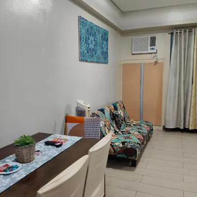 a living room with a table and a couch at LDN Secret Crib 5K- Two Palm Tree in Manila