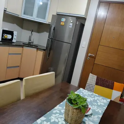 a kitchen with a table and a refrigerator at LDN Secret Crib 5K- Two Palm Tree in Manila