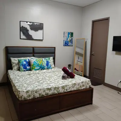 a bedroom with a bed with pillows and a television at LDN Secret Crib 5K- Two Palm Tree in Manila