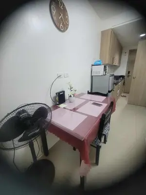 a table and chairs in a kitchen with a clock on the wall at Apartment Condo Unit 1-br Self-contained in Manila