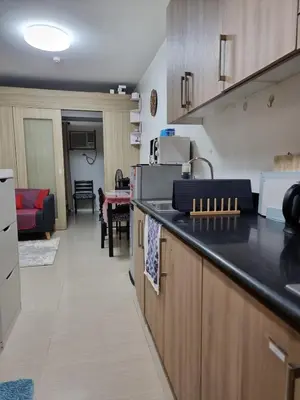 a kitchen with a counter top and a living room at Apartment Condo Unit 1-br Self-contained in Manila