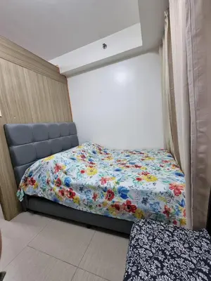a bedroom with a bed with a floral comforter at Apartment Condo Unit 1-br Self-contained in Manila