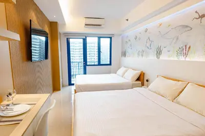 a hotel room with two beds and a table at Hotel-Like Staycation 4 near MOA with WiFi & Netflix in Manila