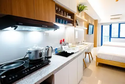 a kitchen with a stove top oven next to a bed at Hotel-Like Staycation 4 near MOA with WiFi & Netflix in Manila