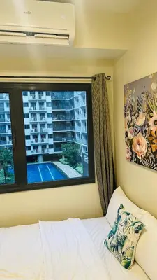 a bedroom with a large window and a bed with a pillow at Luna Suite in Manila