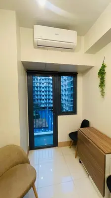 a living room with a window and a air conditioner at Luna Suite in Manila