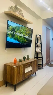 a living room with a large flat screen tv on the wall at Luna Suite in Manila