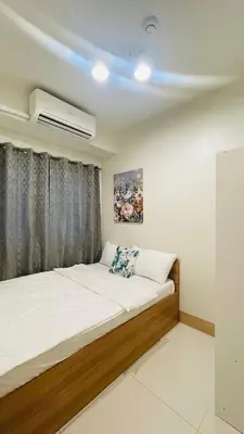 a bedroom with a large bed with a window at Luna Suite in Manila