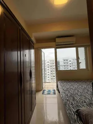 a bedroom with a bed and a large window at Dona staycation in Manila
