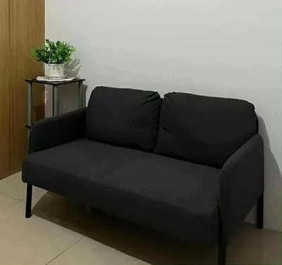 a black couch sitting in a living room at Dona staycation in Manila