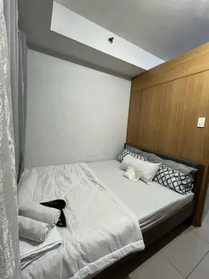 a bedroom with a large bed with a wooden headboard at Dona staycation in Manila