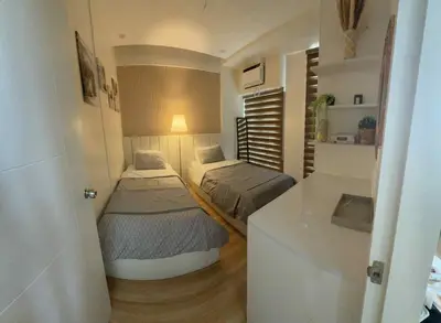 a small room with two beds and a counter at Miyu's Staycation Place in Biñan