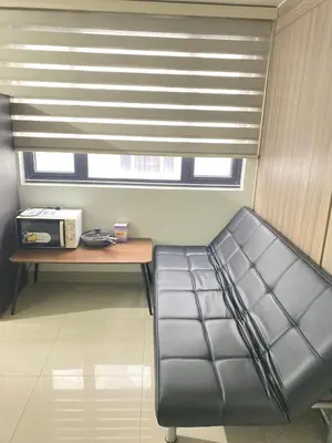 a couch in a room with a table and a window at SHORE 2 tower 2 in Manila