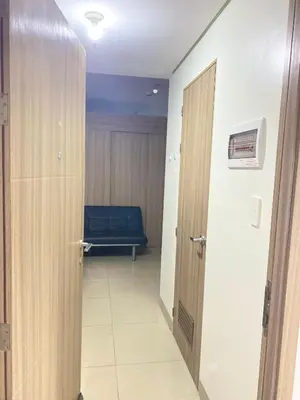 a hallway with a door and a bench in a room at SHORE 2 tower 2 in Manila