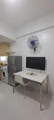 a white kitchen with a table and a refrigerator at Soap's Haven Rental Unit in Paranaque in Manila