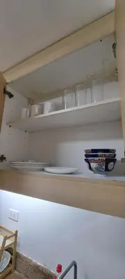 a kitchen shelf with plates and bowls on it at Soap's Haven Rental Unit in Paranaque in Manila