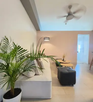 a living room with two plants and a suitcase at Modern Bright Cozy Stylish 1BR Venice BGC Balcony in Manila